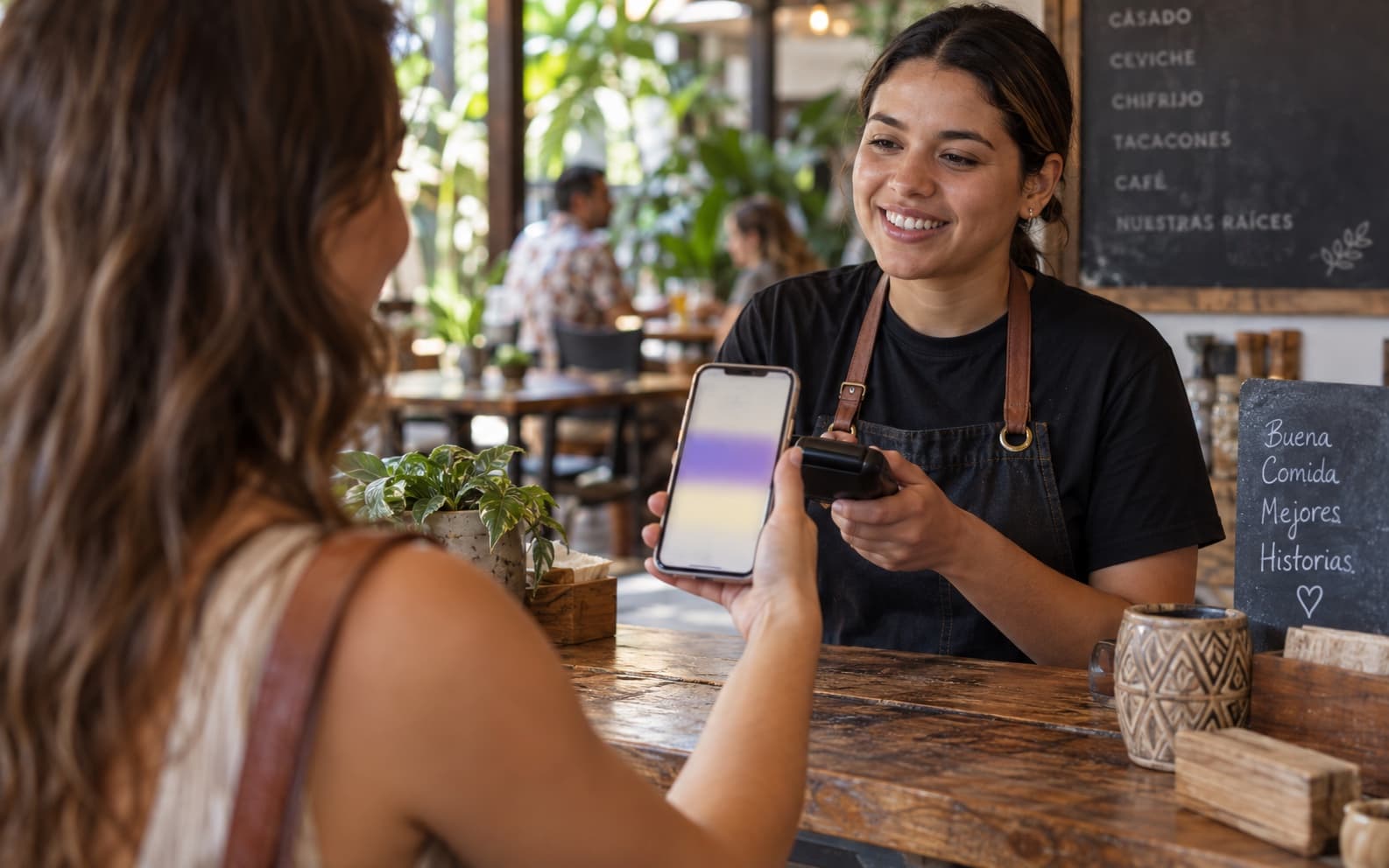 Clienta presenta su teléfono al personal en el mostrador