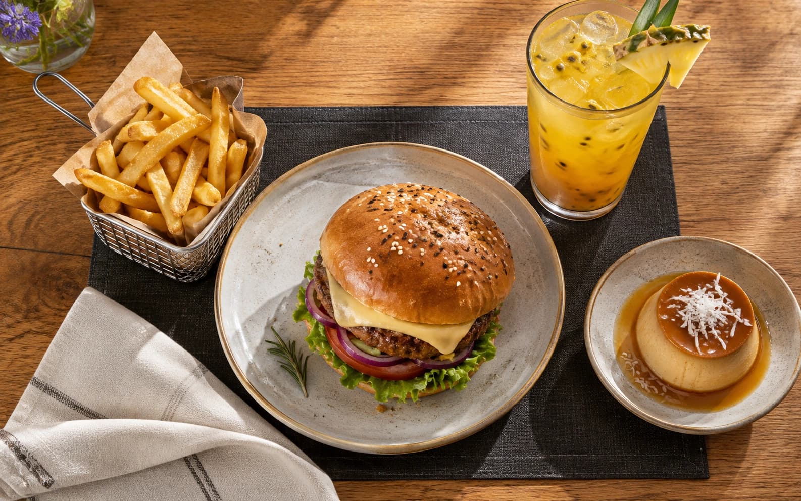 Combo de hamburguesa, papas, bebida y flan presentado sobre una mesa de restaurante